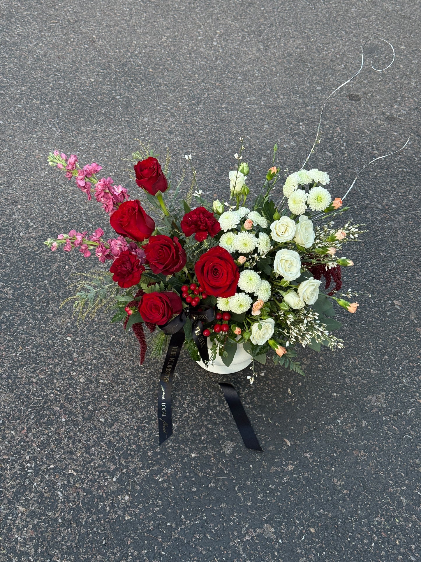 Romantic red and burgundy floral table centerpiece with white blooms in a luxurious design