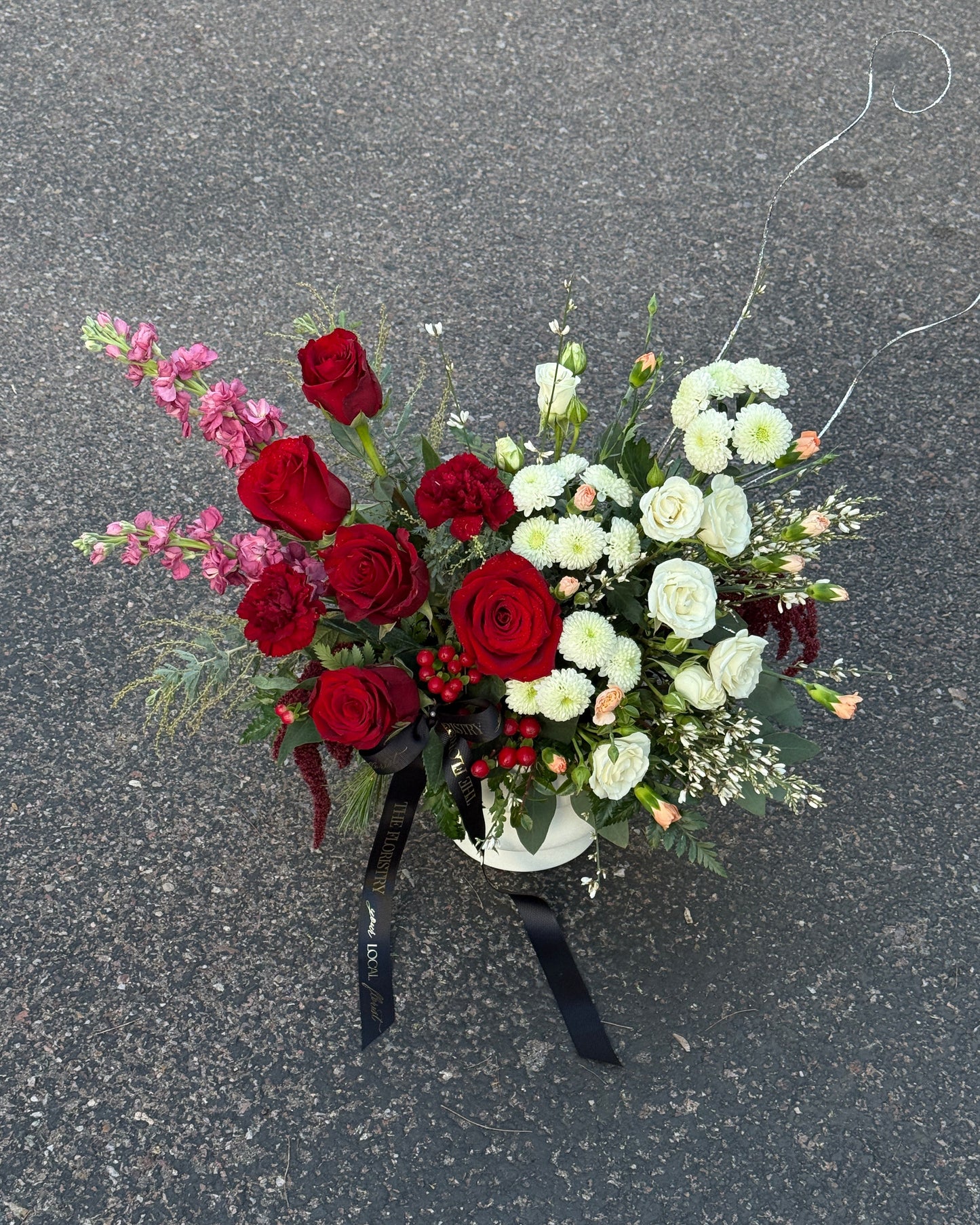 Romantic red and burgundy floral table centerpiece with white blooms in a luxurious design