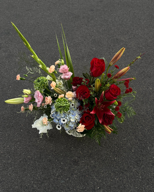 Luxury florist designed red and crimson centerpiece with rich texture and depth. Lilies, hydrangeas, rannunculus