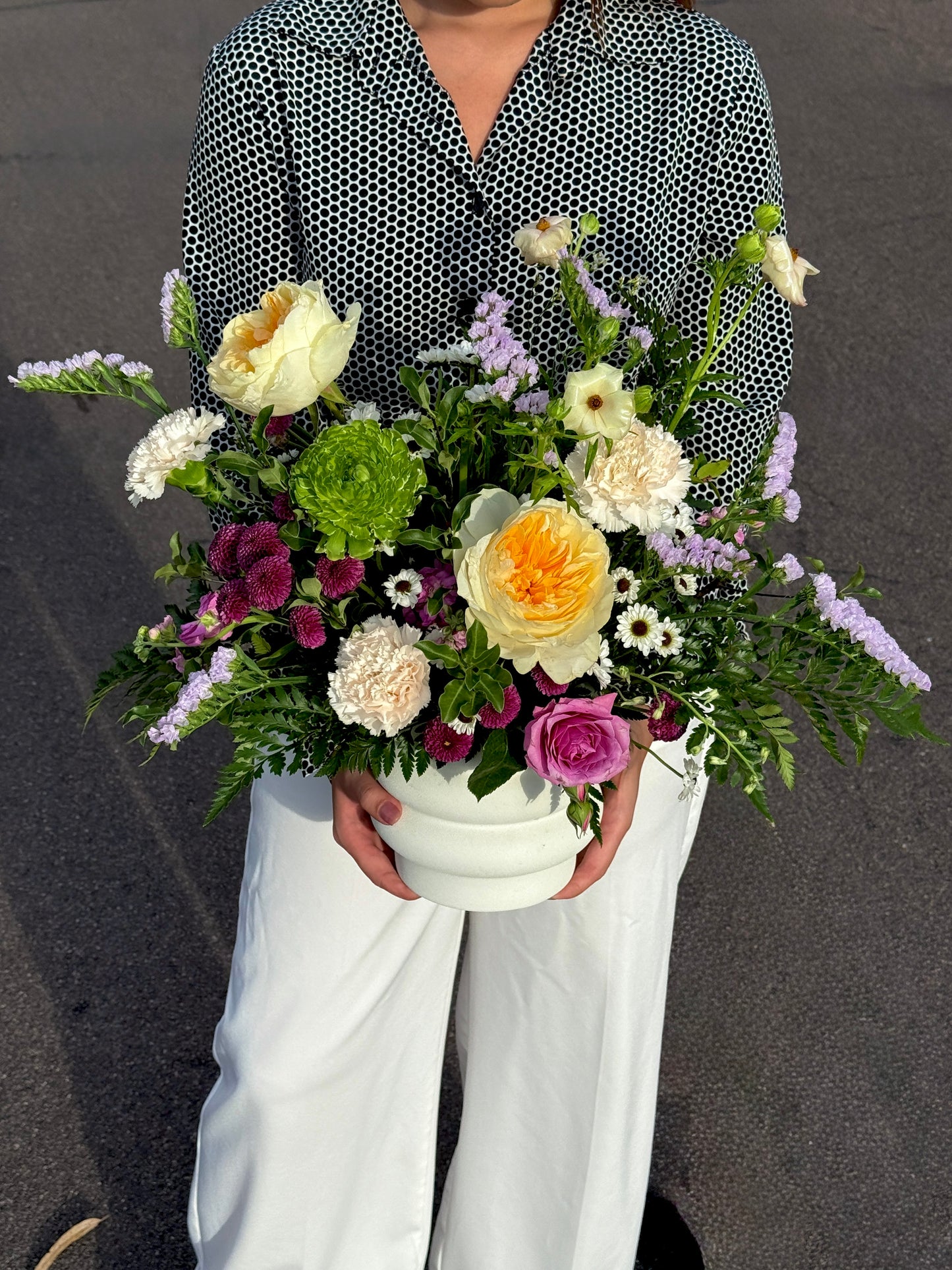 Colorful spring mix centerpiece arranged with seasonal flowers showcasing natural movement and garden inspired style.