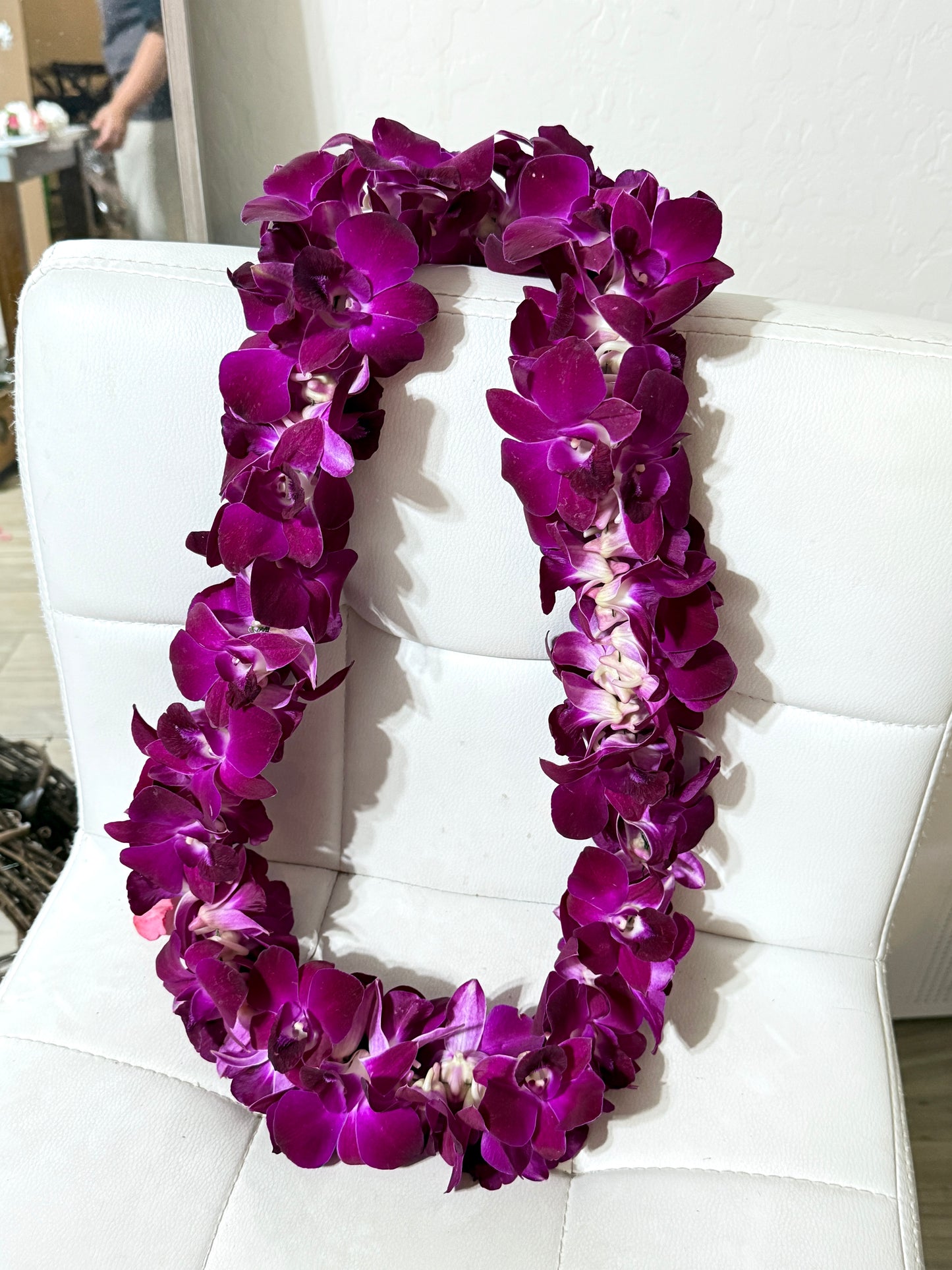 Purple and white orchid lei perfect for graduation celebrations, showcasing delicate orchid blooms.