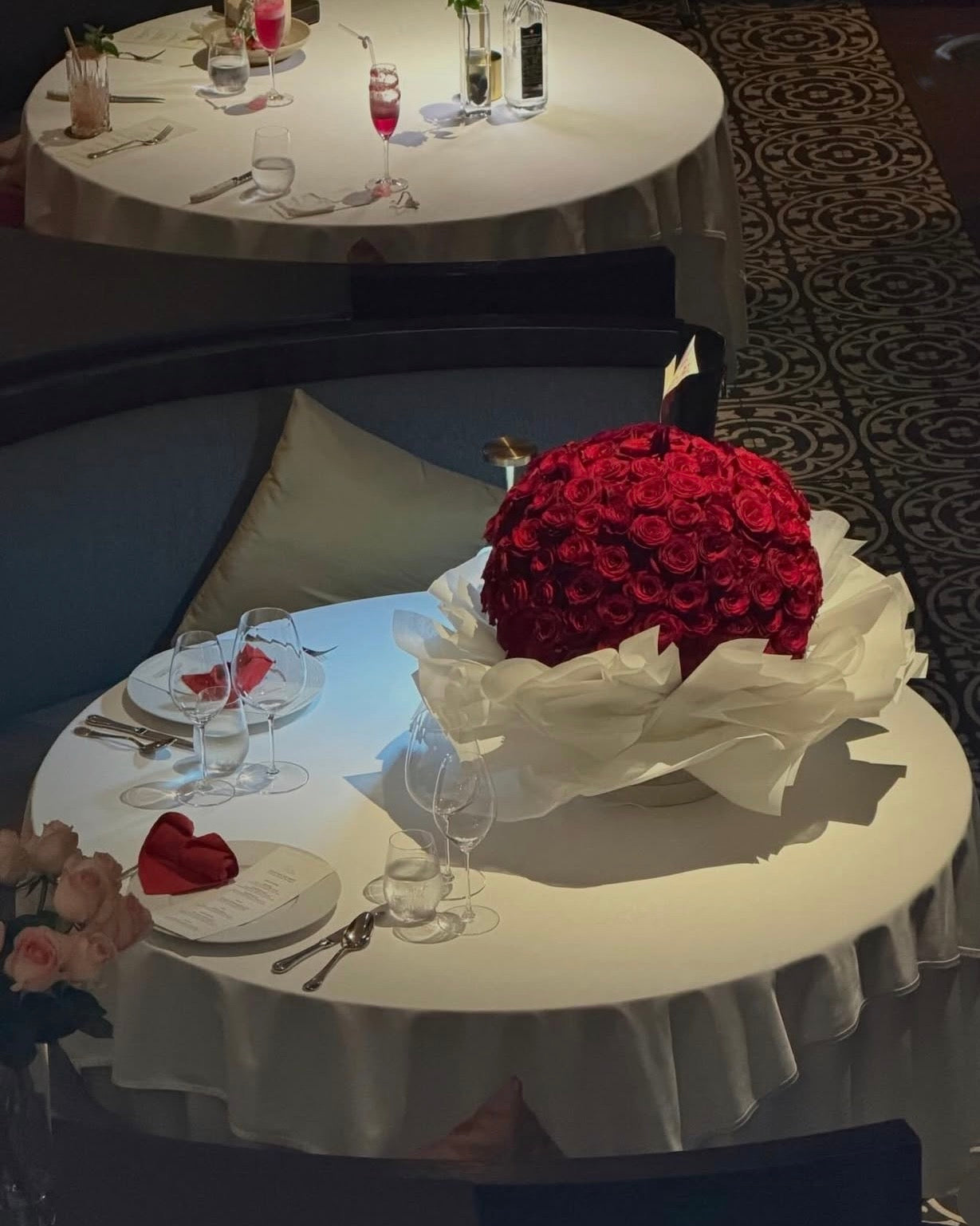 Luxurious large bouquet of deep red roses, arranged elegantly with lush greenery and accent flowers, perfect for a romantic or special occasion."