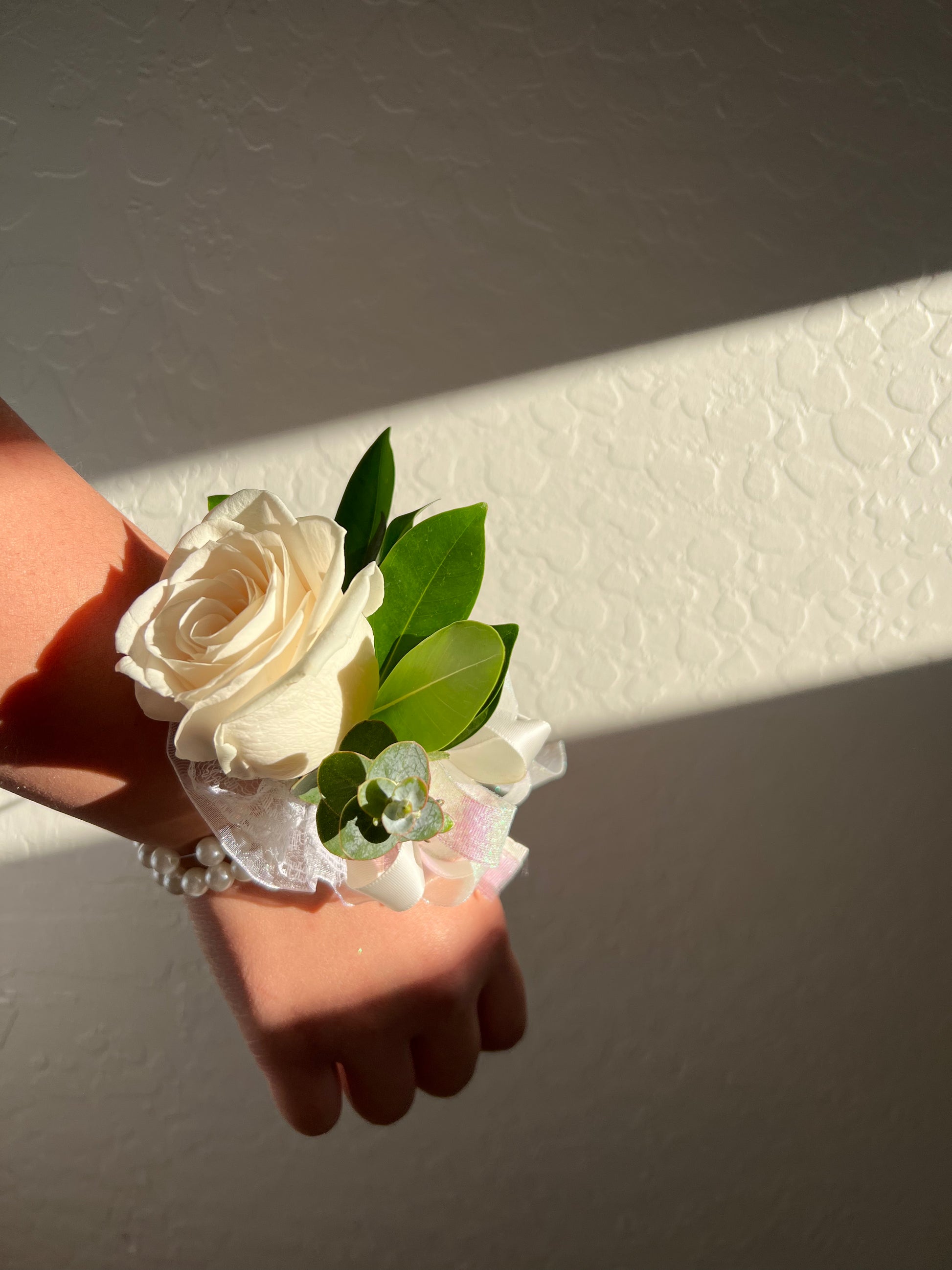 Fresh rose prom corsage with greenery and ribbon
