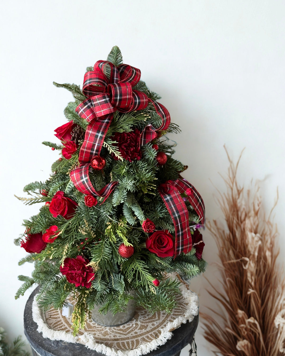beauty of winter indoors with our Winter Bloom Spruce. Featuring festive red decorations paired with lush, long-lasting holiday foliage.