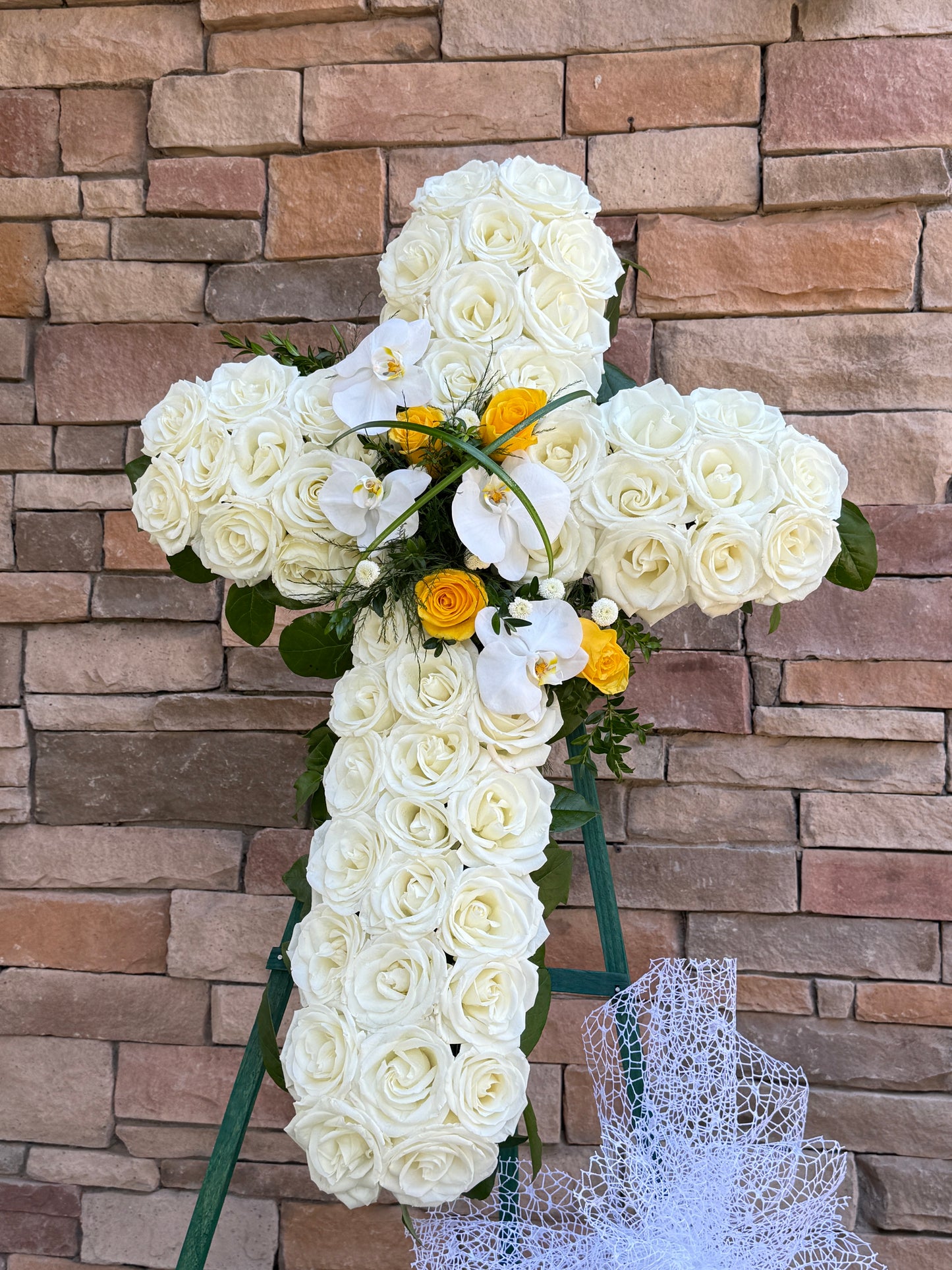 Floral cross stand funeral arrangement available for delivery in Gilbert, Chandler, Tempe, Queen Creek, and Mesa with elegant sympathy flowers.