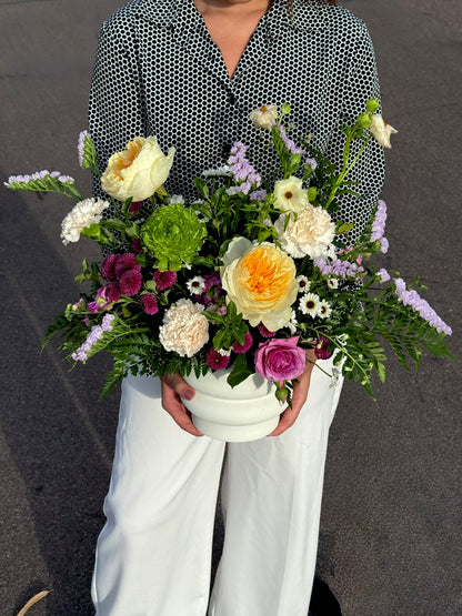 Colorful spring mix centerpiece arranged with seasonal flowers showcasing natural movement and garden inspired style.