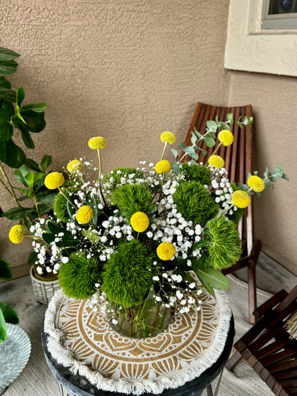 Vibrant First Day Bouquet featuring textured dianthus and sunny billy yellow balls. Available in deluxe and premium sizes. Perfect for brightening any space or gifting.