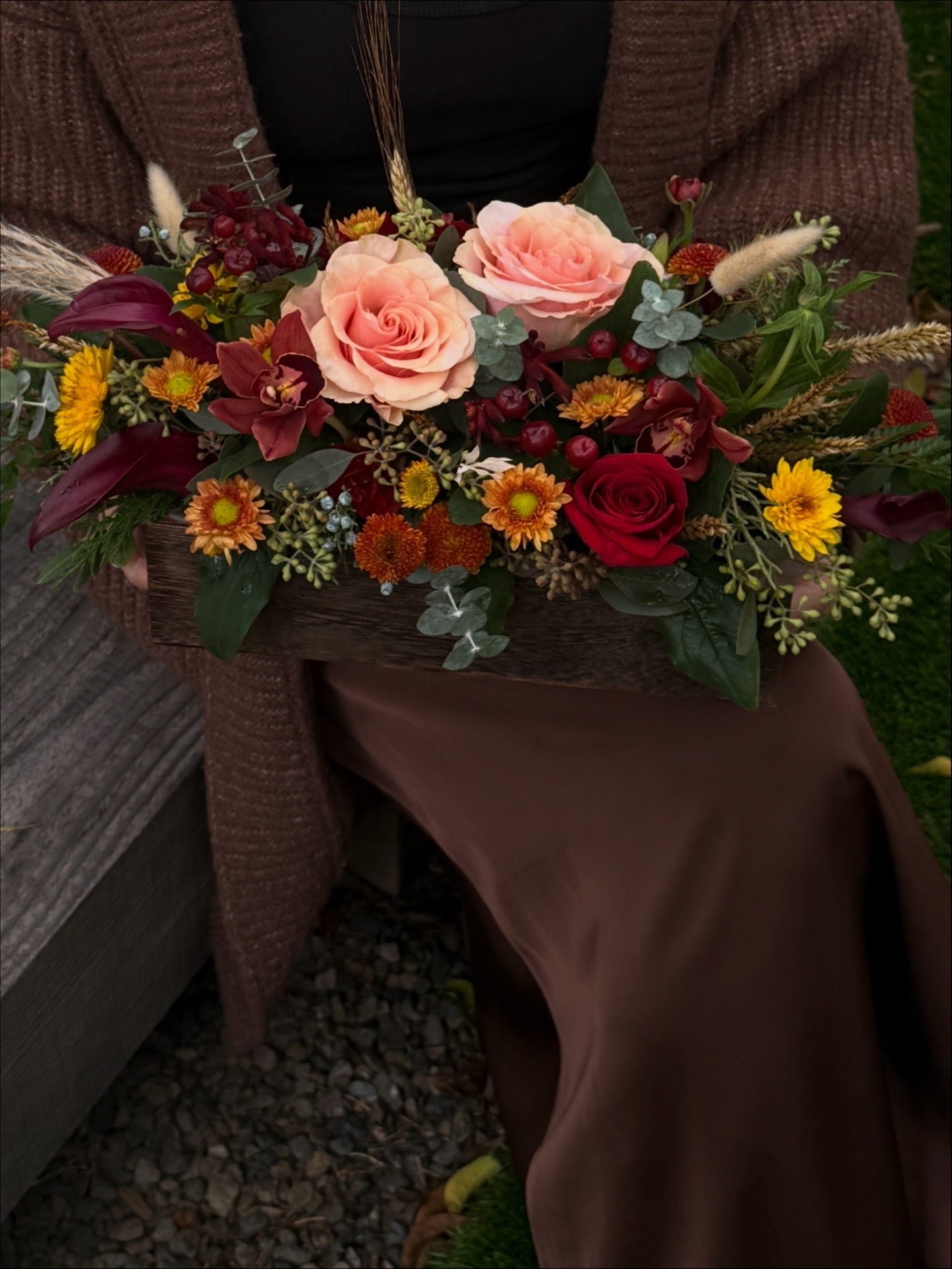 A rustic wooden box filled with a colorful autumnal floral arrangement. Flowers delivered in Gilbert, Queen Creek, Chandler, Mesa