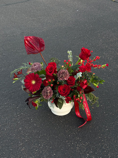 Bouquet of red and purple flowers with ribbons with anthurium, gerber daises, red roses, carnations, calla lilies.