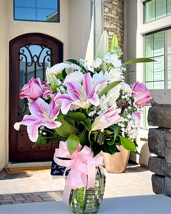 Elegant white and pink roses and blooms in a vase, handcrafted by florists for same day delivery.
