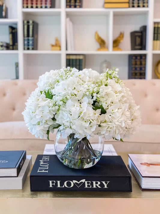 A large, fluffy white bouquet of flowers arranged in a clear glass vase. Same day flower delivery